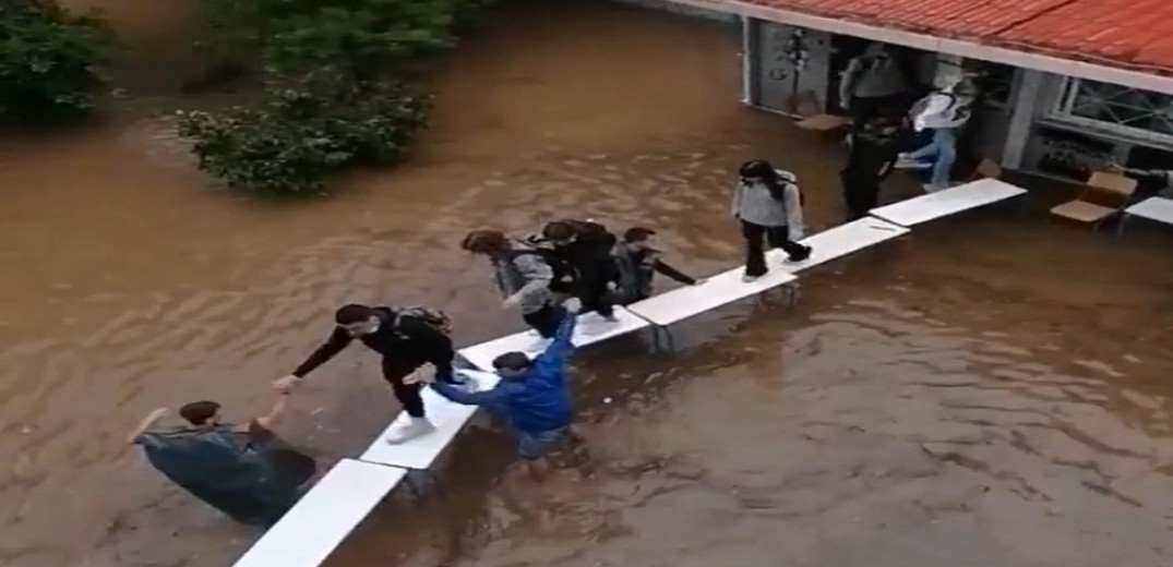 Απίστευτες εικόνες: Μαθητές στην Αθήνα εγκαταλείπουν το πλημμυρισμένο σχολείο πάνω σε θρανία (βίντεο)